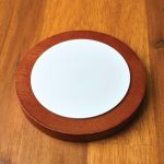 A wireless charger featuring a sleek design with a wooden base and a smooth white charging surface.