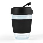 A reusable coffee cup with a transparent body and a black flip lid. The cup features a black silicone sleeve for grip.