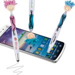 A set of colorful stylus pens with playful character toppers, featuring pink and blue accents, resting near a smartphone.