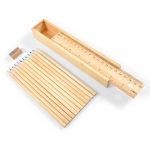 A set of wooden coloured pencils in various colors, a sharpener, and a measuring ruler all in a wooden box.