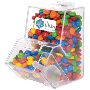A clear dispenser filled with colorful M&M's chocolate candies, featuring a branded label on the front.