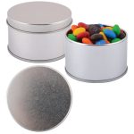 A silver round tin filled with colorful M&M's candies, featuring a smooth metal lid.