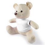 A plush bear with a beige body and a white shirt, featuring a brown nose and round ears.