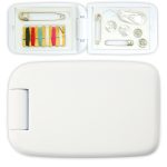 A white sewing kit with various threads, buttons, safety pins, and a needle inside a compact case.