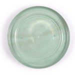 A round, translucent green flyer with a smooth surface and a subtle marbled effect. Features a logo on the bottom.