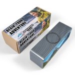 A rectangular speaker in a textured black finish alongside its branded packaging featuring outdoor imagery and logos.