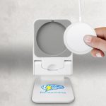 A white magnetic wireless charger with a logo, featuring a round charging pad and a hand holding a device.