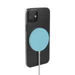 A black smartphone with a teal circular magnetic wireless charger attached, featuring a charging cable.