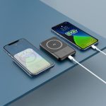 A black 5000 mAh MagSafe power bank displayed alongside two smartphones, showcasing wireless charging features.