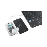 A wireless charger in black connected to a laptop, with a smartphone's back cover removed nearby.