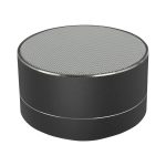 A round black Bluetooth speaker featuring a silver trim and a textured speaker grille on top.