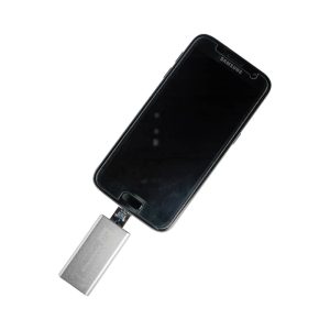A silver Banion OTG USB 3.0 flash drive connected to a black smartphone. The device has a logo on it.