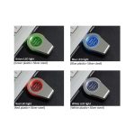 A collection of four flash drives with different LED light colours: green, blue, red, and white, on a silver background.