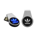 A sleek silver LED flash drive with a black logo, featuring a blue glowing light.