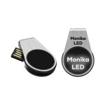 A silver LED flash drive with a black circular section and a branding logo. The drive has a retractable connector.