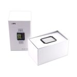 A smart watch in a black and silver design, displayed in an open white box. The box has branding on it.