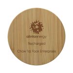 A round bamboo wireless charger with a wooden texture and a logo. It features engraved text.