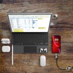 A flat lay featuring a laptop, smartphone, mouse, earbuds, and a Vinci LED Data Charge Cable in black.