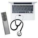 A silver tool kit with various bits, a black stethoscope, and a silver laptop keyboard. The kit includes a logo.