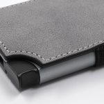 A grey vegan RFID wallet with a textured finish and contrasting stitching, featuring a black edge.