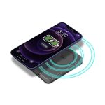 A black magnetic wireless power bank with charging indicator, placed under a smartphone displaying a charging symbol.