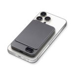 A grey magnetic wireless power bank sits on a smartphone, featuring a sleek design and a logo.
