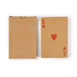 A deck of recycled playing cards in a brown cardboard box, featuring a red Ace of Hearts on top.