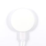 A circular, magnetic wireless charger with a white surface and a white cable attached.