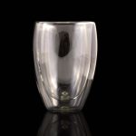 A double wall glass cup in clear color, designed to hold beverages, featuring a sleek, modern shape and a logo.