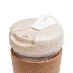 A reusable coffee cup featuring a cork band, with a lid made from a sustainable material that has a speckled design.