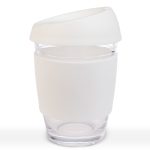 A reusable coffee cup in transparent glass with a white silicone lid and sleeve. Features a logo.