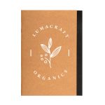 A brown A5 notebook with a black spine and a logo featuring a leaf and berries on the cover.