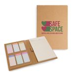 A cork-bound Daily Note Planner with colorful sticky notes and a notepad, featuring a logo on the cover.