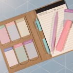 A Daily Note Planner in a kraft cover with pastel-coloured sticky notes, a pink pen, and a highlighter.
