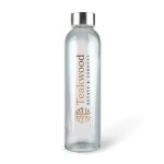 A drink bottle made of clear glass with a silver metal lid and a logo on the side.