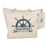 A beige canvas tote bag featuring a nautical steering wheel design and a small matching pouch.