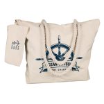 A cream-colored tote bag with blue nautical-themed design and rope handles, featuring a detachable pouch.