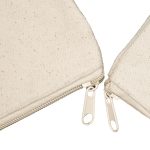 A beige canvas tote bag with a textured surface and two zippered compartments.