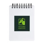 A spiral-bound pocket notebook with a white cover featuring the logo of "Outland Hunters" in green and black.