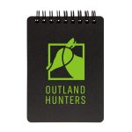 A spiral-bound pocket notebook featuring a black cover and a green logo with the text "OUTLAND HUNTERS."