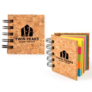 A cork sticky notes book with colorful sticky notes inside, featuring a logo on the cover.