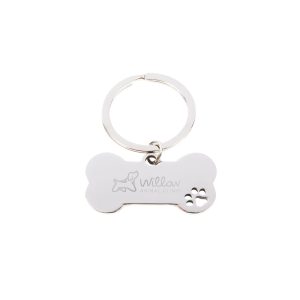 A silver dog bone keytag featuring a paw print design and an engraved logo.