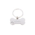 A silver keytag shaped like a dog bone with a small paw print design and a logo.