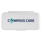 A compact pill organizer featuring a white exterior with a logo that reads "COMPASS CARE."
