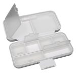 A compact pill organizer in white with multiple compartments and clear lids for easy access to contents.