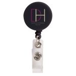 A retractable name badge holder in black with a clear strap and a circular logo attachment.