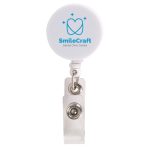 A white retractable name badge holder with a circular top and a metal clip, featuring a logo.