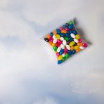 A pillow pack filled with assorted color mini jelly beans, including red, yellow, green, blue, and white.