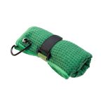 A green travel towel, rolled up with a black strap and carabiner for attachment. It has a textured surface.