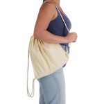 A cream-coloured drawstring backpack is shown slung over one shoulder, featuring a simple design and a logo.
